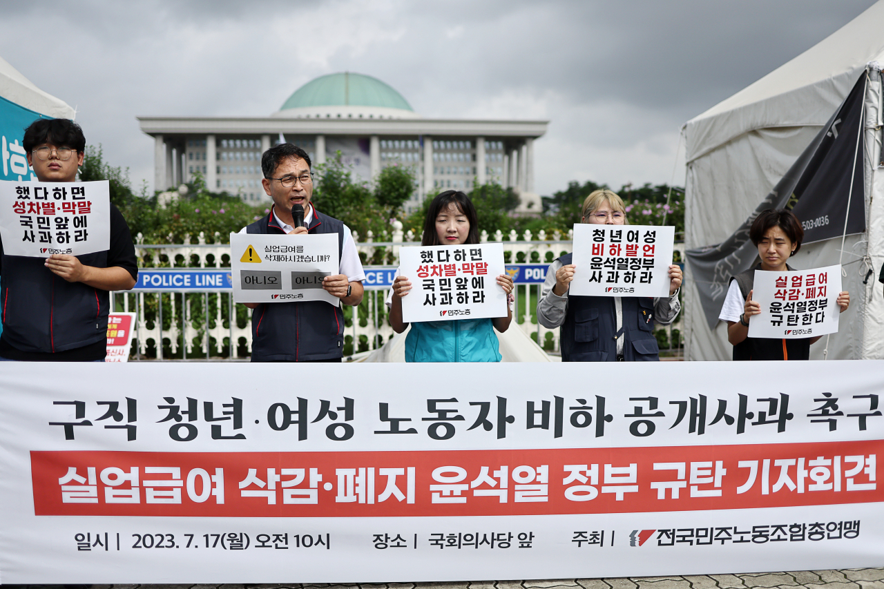 17일 국회 앞에서 열린 ‘실업급여 삭감·폐지 윤석열 정부 규탄 기자회견’에서 민주노총 관계자들이 관련 손피켓을 들고 있다. [연합]