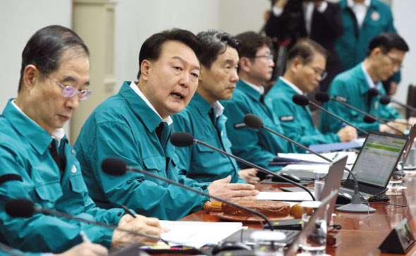윤석열 대통령이 녹색 민방위복 차림으로 18일 서울 용산 대통령실 청사에서 국무회의를 주재하고 있다. 윤 대통령은 특별재난지역 선포와 예비비 지출 등 가용한 모든 자원을 동원해 폭우 피해 대책을 실행할 것을 지시했다. [연합]