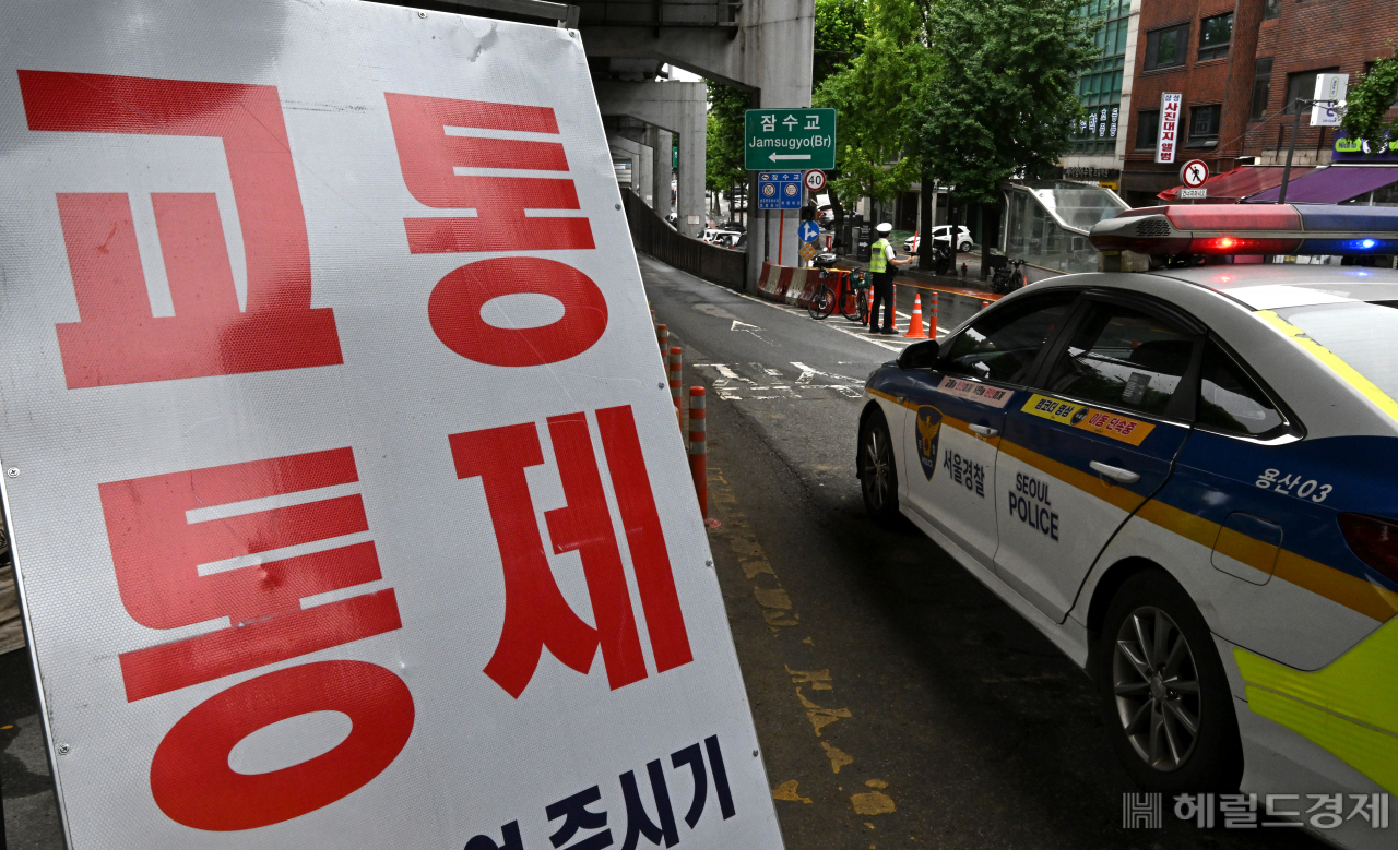 18일 서울 용산구 잠수교 북단 입구에서 경찰이 차량 진입을 통제하고 있다. 잠수교는 한강 수위가 낮아지며 수면 위로 모습을 드러냈으나 토사와 부유물로 인해 안전 점검과 보수작업을 마친 후 통행이 재개될 것으로 보인다. 임세준 기자