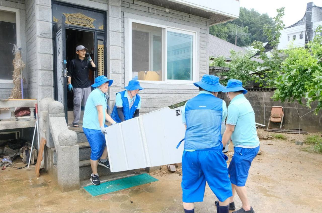 삼성전자서비스 임직원이 침수된 냉장고의 건조 및 세탁을 위해 냉장고를 외부로 옮기고 있다. [삼성전자서비스 제공]