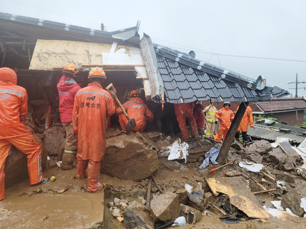 Firefighters carry out a rescue operation after a house was destroyed by landslides in Yeongju, North Gyeongsang Province, Saturday. (Yonhap)