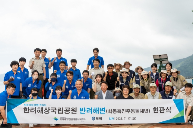 17일 거제시 학동흑진주몽돌해수욕장에서 이종수 무학사장(앞줄 네 번째)과 신창호 한려해상국립공원동부사무소장(앞줄 다섯 번째) 등이 환경정화 활동을 진행하고 파이팅을 외치고 있다. [사진=무학]