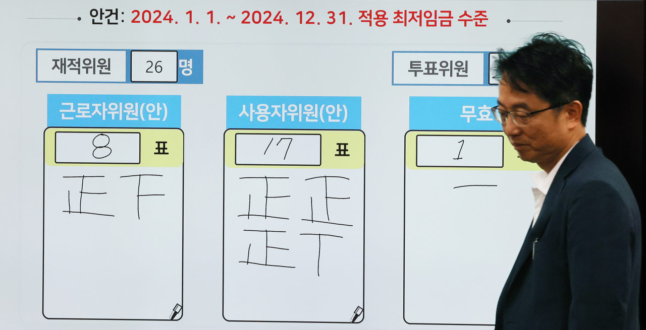 2024년도 최저임금이 9천860원으로 결정됐다. 19일 새벽 세종시 정부세종청사 최저임금위원회 회의실 모니터에 표결 결과가 게시되어 있다. 오른쪽은 박준식 위원장. 연합뉴스
