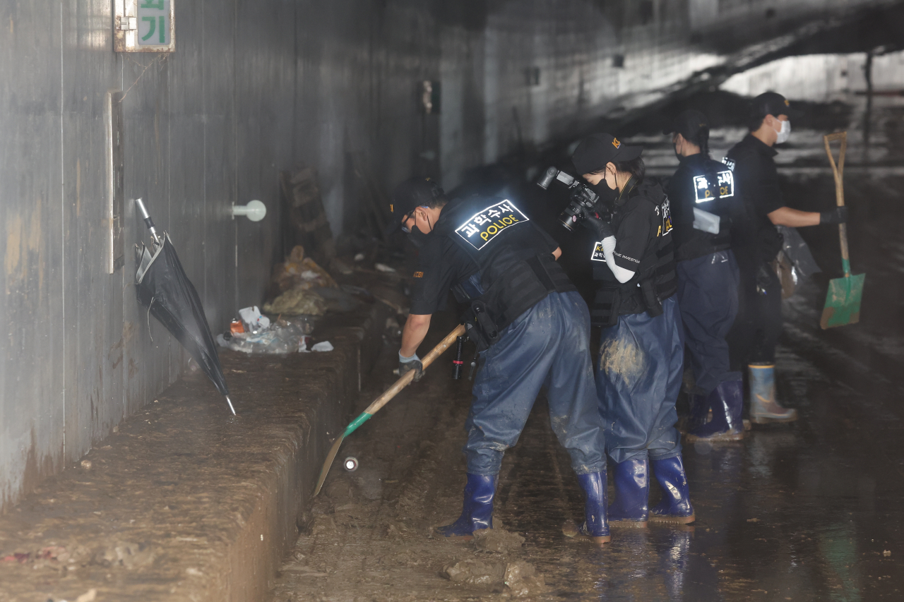 지난 18일 미호천 제방 유실로 침수된 충북 청주시 오송읍 궁평2지하차도 수색구조현장에서 경찰 과학수사대 관계자들이 희생자 유류품 수색을 하고 있다. [연합]