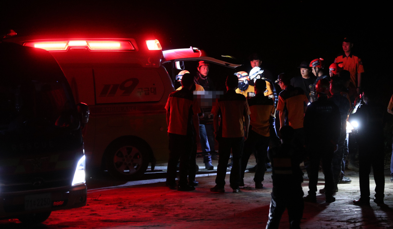 Rescue workers carry the body of a marine to an ambulance in Yecheon on Wednesday. He went missing earlier in the day after being swept away by a torrent while participating in search and rescue operations in the area. (Yonhap)