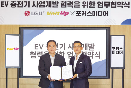 현준용(왼쪽) LG유플러스 EV충전사업단장과 윤제현 포커스미디어코리아 대표가 업무협약을 체결한 뒤 기념촬영을 하고 있다. [LG유플러스 제공]