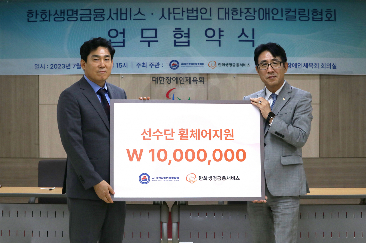 박종선(오른쪽) 한화생명금융서비스 금융소비자보호실장이 20일 대한장애인체육회에서 대한장애인컬링협회 측에 1000만원 상당의 선수용 휠체어를 지원한 후 서원영 대한장애인컬링협회 실무 부회장과 기념 촬영을 하고 있다. [한화생명서비스 제공]