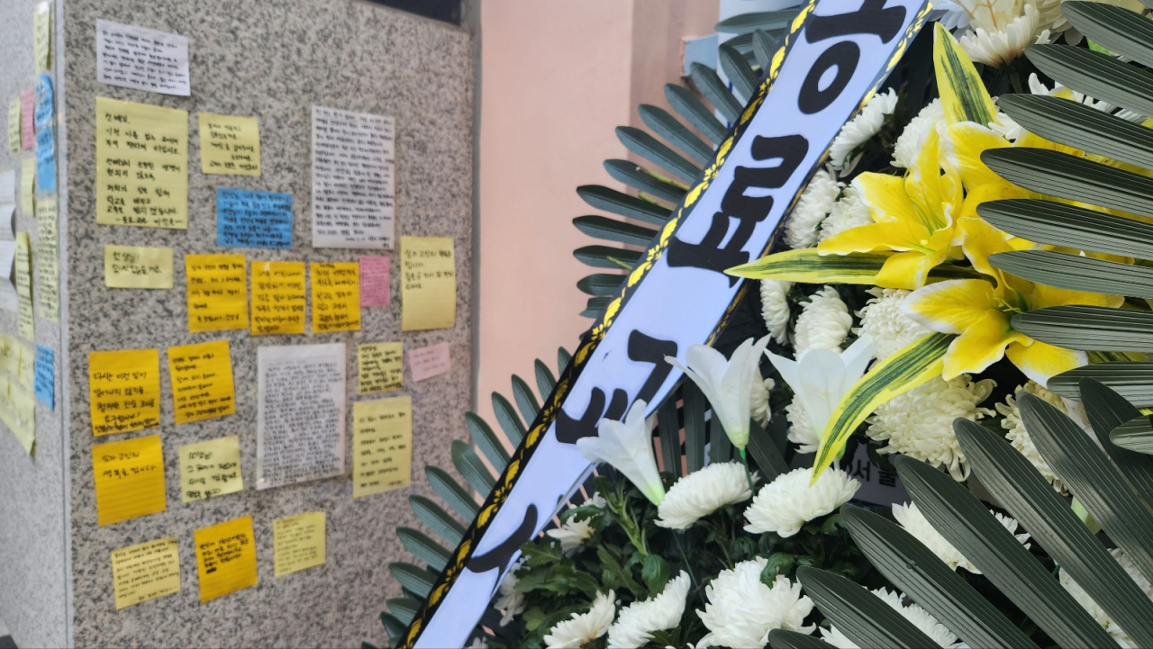서울 서이초등학교 교문 앞에 게시된 지난 18일 사망한 교사 A씨를 기리는 메모와 화환. [안효정 기자]