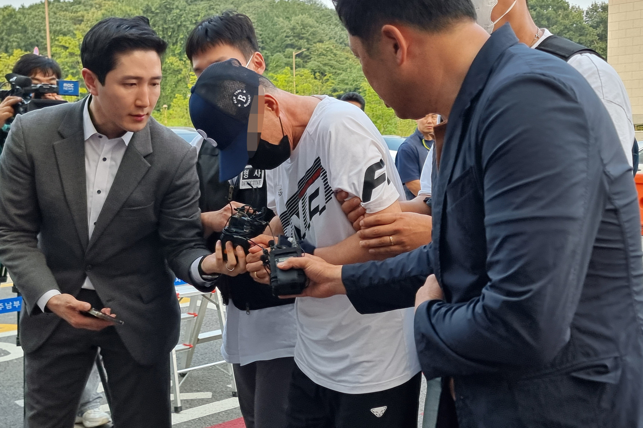 21일 경기도 남양주시 다산동 남양주남부경찰서에서 경찰이 모녀를 살해하고 달아난 혐의를 받는 용의자 A씨(가운데)를 압송하고 있다. [연합]