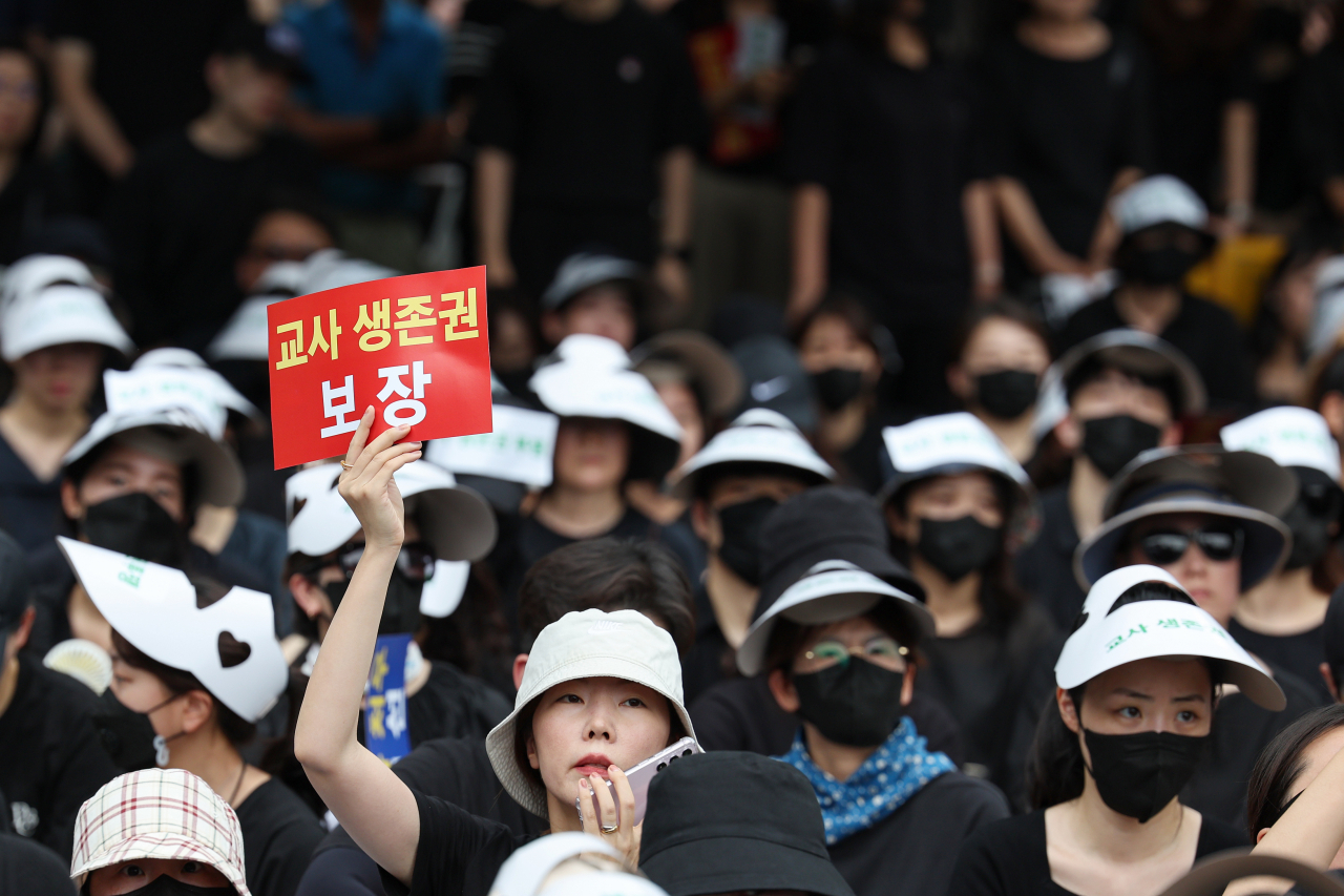 서울 서초구의 한 초등학교에서 발생한 교사 사망 사건과 관련해 22일 오후 서울 종로구 보신각 인근에서 열린 추모식에서 한 참가자가 손팻말을 들고 있다. [연합]