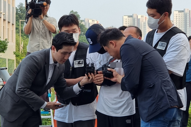 지난 21일 경기 남양주시 다산동 남양주남부경찰서에서 취재진이 모녀를 살해하고 달아난 혐의를 받는 용의자 A씨(가운데)에게 질문을 하고 있다. [연합]