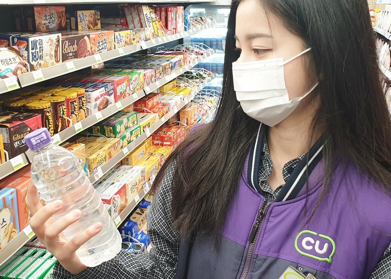 서울 마포구에서 5년째 편의점을 운영하는 김모(56)씨는 “이미 알바생을 최소한만 고용해 하루에 14시간을 일한다. 알바생도 투잡, 쓰리잡하고 있어 서로 불편한 상황”이라고 말했습니다. 사진은 CU 자체브랜드 생수를 든 직원. [CU 제공]