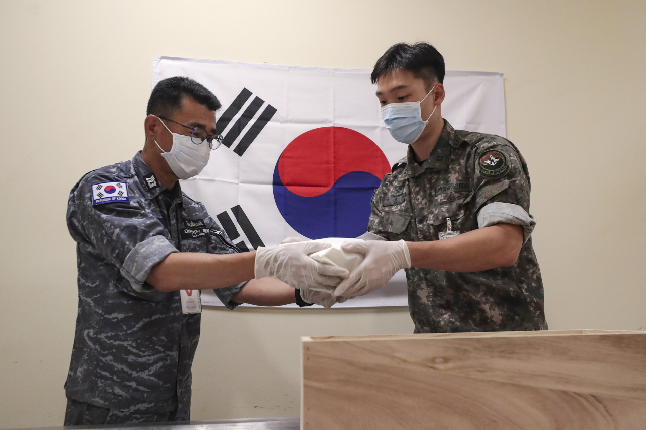故 최임락 일병의 유가족(조카)인 최호정 해군 상사와 국방부 유해발굴감식단 유해인수 장병이 24일(현지시간) 미국 하와이 소재 미 국방부 전쟁포로 및 실종자 확인국(DPAA) 중앙감식소에서 고인의 유해를 입관하고 있는 모습입니다.[국방일보 제공]
