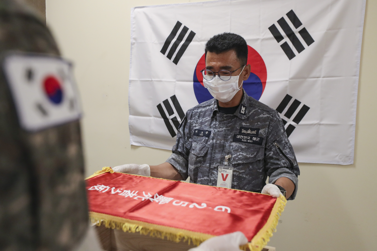 故 최임락 일병의 유가족(조카)인 최호정 해군 상사가 24일(현지시간) 미국 하와이 소재 미 국방부 전쟁포로 및 실종자 확인국(DPAA) 중앙감식소에서 고인의 유해를 입관한 뒤 관포하고 있는 모습입니다.[국방일보 제공]