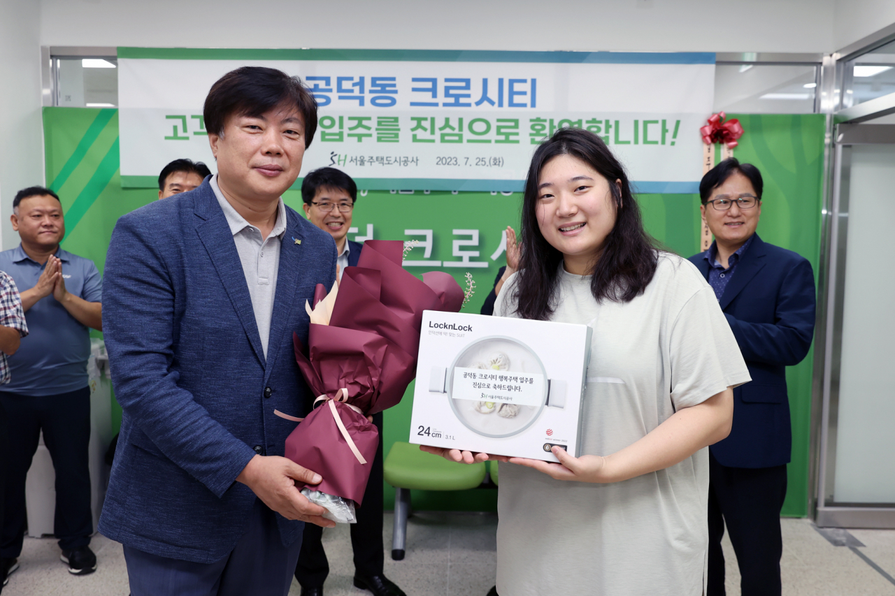 조대원 SH공사 건설사업본부장(왼쪽)이 첫 입주민에게 기념품을 증정하고 있다.