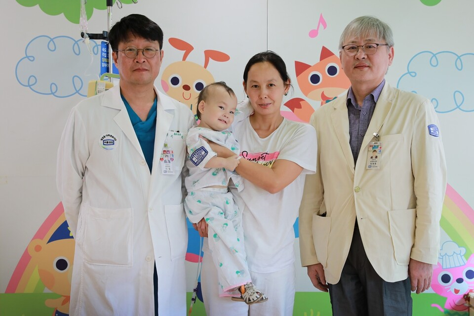이철(왼쪽) 서울성모병원 심장혈관흉부외과 교수와 이재영 소아청소년과 교수가 선천 심장 질환을 앓았던 카자흐스탄 아미나 베케쉬 양의 퇴원을 앞두고 보호자 디나라 무카노바 씨와 기념 촬영을 했다. [서울성모병원 제공]