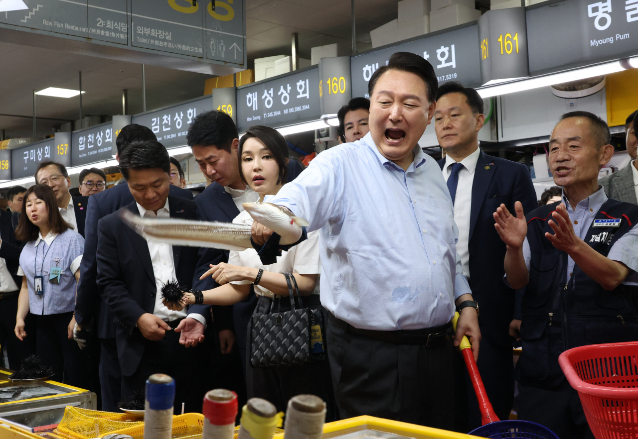 윤석열 대통령이 27일 부산 중구 자갈치시장에서 장어를 직접 손으로 잡아 보며 즐거워 하고 있다. [연합]