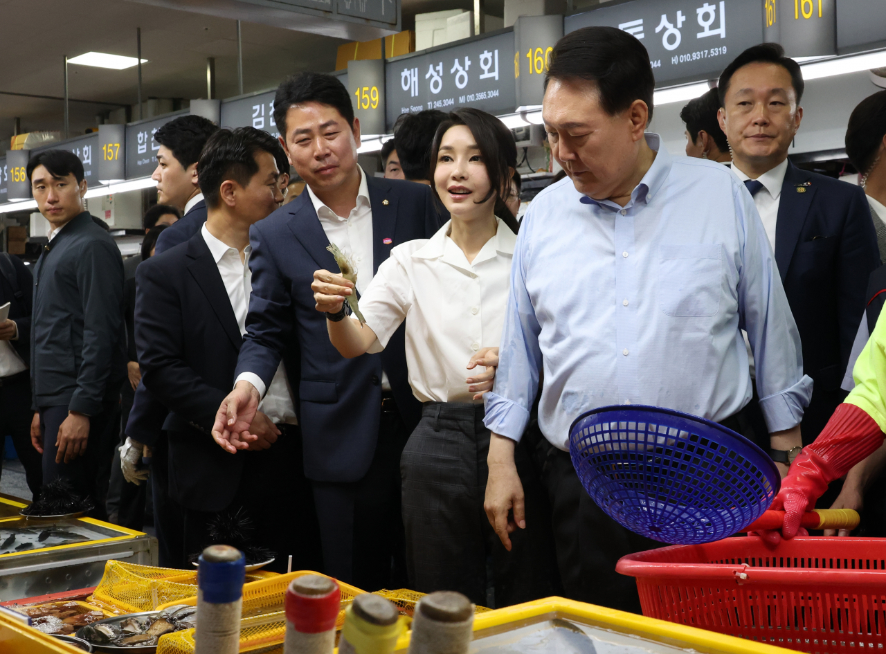윤석열 대통령과 함께 부산을 찾은 김건희 여사가 27일 부산 중구 자갈치시장에서 수산물을 살펴보다 새우를 직접 집어보고 있다. [연합]