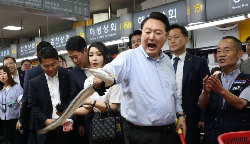 윤석열 대통령이 27일 부산 중구 자갈치시장에서 장어를 직접 손으로 잡아 보며 즐거워 하고 있다. [연합]