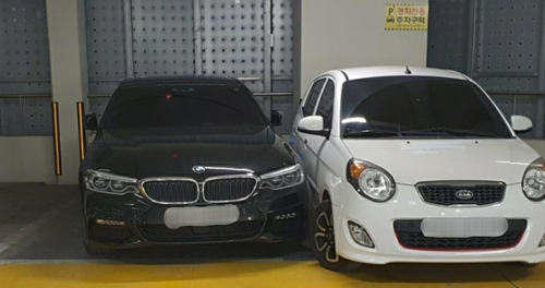 '민폐' 외제차 응징한 경차 주차선을 넘어온 BMW 차량 옆에 경차가 주차돼 있다. BMW 차주는 차를 못 빼 경찰의 도움을 받았다. [연합]