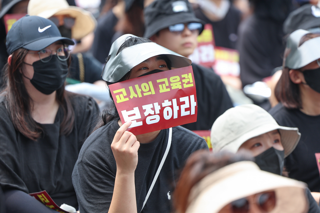 전국 각지에서 모인 교사들이 지난달 29일 서울 종로구 경복궁역 사거리 인근에서 열린 공교육 정상화를 위한 집회에서 팻말을 들고 있다. [연합]