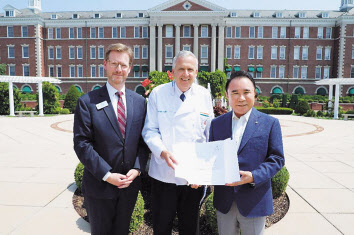 윤홍근(오른쪽 첫 번째) 제너시스BBQ그룹 회장이 세계 3대 요리학교인 CIA 본교인 하이드파크 캠퍼스(미국 뉴욕주)를 방문, CIA의 마크 에릭슨(가운데) 총장·빌 리디 대외업무 부서장으로부터 팀 라이언 학교장 명의의 감사장을 전달받고 있다. [제너시스BBQ그룹 제공]