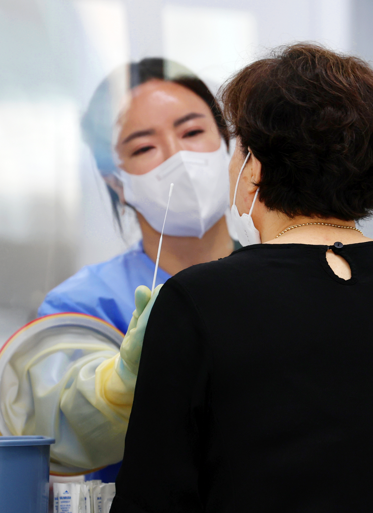 폭염 특보가 8일째 발효 중인 1일 오전 광주 서구보건소에 설치된 선별진료소에서 의료진이 신종 코로나바이러스 감염증(코로나19) 검체 채취를 하고 있다. [연합]
