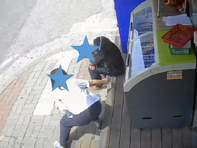 서울 한 편의점 앞에서 한 여성이 땡볕 속에 고개를 떨군 채 쭈그려 앉아 있는 중년남성 옆에 생수를 놓아주고 있다. 매장 입구 CCTV에 찍힌 장면이다. [온라인 커뮤니티 갈무리]