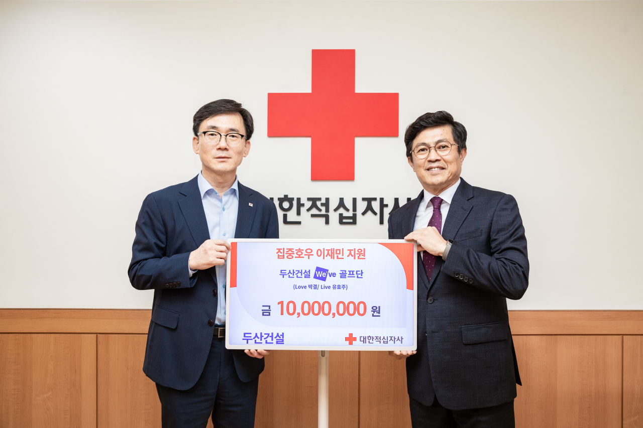 이상천 대한적십자사 사무총장과 오세욱 두산건설 상무(왼쪽부터)가 수해복구 성금 전달식을 가지고 있다.