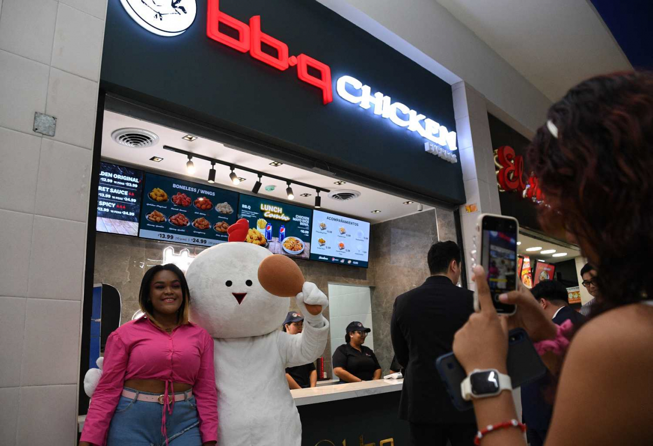 BBQ 파나마 2호점 ‘알브룩점’을 방문한 현지 고객이 BBQ 마스코트인 치빡이와 기념촬영을 하고 있다. [제너시스BBQ그룹 제공]