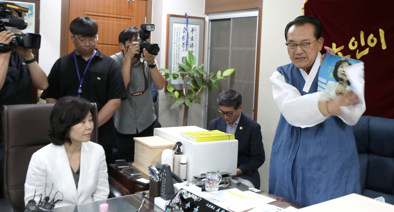 3일 용산 대한노인회 중앙회에서 김호일 회장이 노인폄하 발언 사과를 위해 방문한 더불어민주당 김은경 혁신위원장과 면담 중 위원장의 뺨 대신 사진을 때리고 있다. [연합]