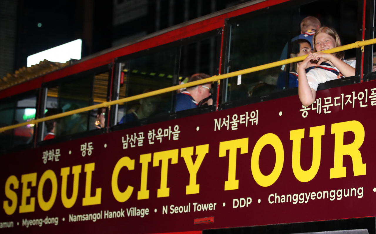 2023 새만금 세계 스카우트 잼버리에서 조기 퇴영한 영국 스카우트 대원들이 6일 밤 광화문 서울 시티투어버스에 탑승해 출발을 기다리고 있다. [연합]