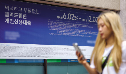 서울 한 시중은행의 대출 안내문 앞을 시민이 지나가고 있다. [연합]