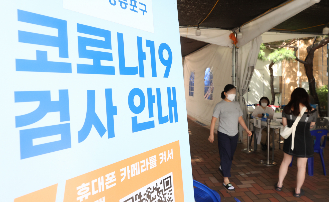 5주 연속 코로나 19 확진자 증가세가 이어지고 있는 2일 오후 서울 한 보건소 선별진료소에서 시민들이 PCR 검사를 받기 위해 문진표를 작성하고 있다. [연합]