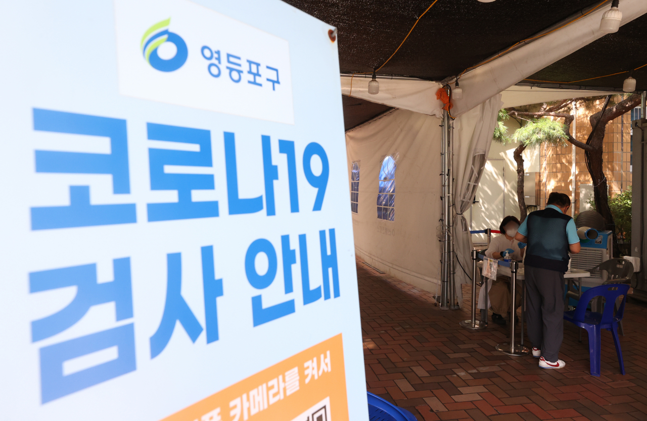 5주 연속 코로나 19 확진자 증가세가 이어지고 있는 2일 오후 서울 한 보건소 선별진료소에서 시민들이 PCR 검사를 받기 위해 문진표를 작성하고 있다.[연합]