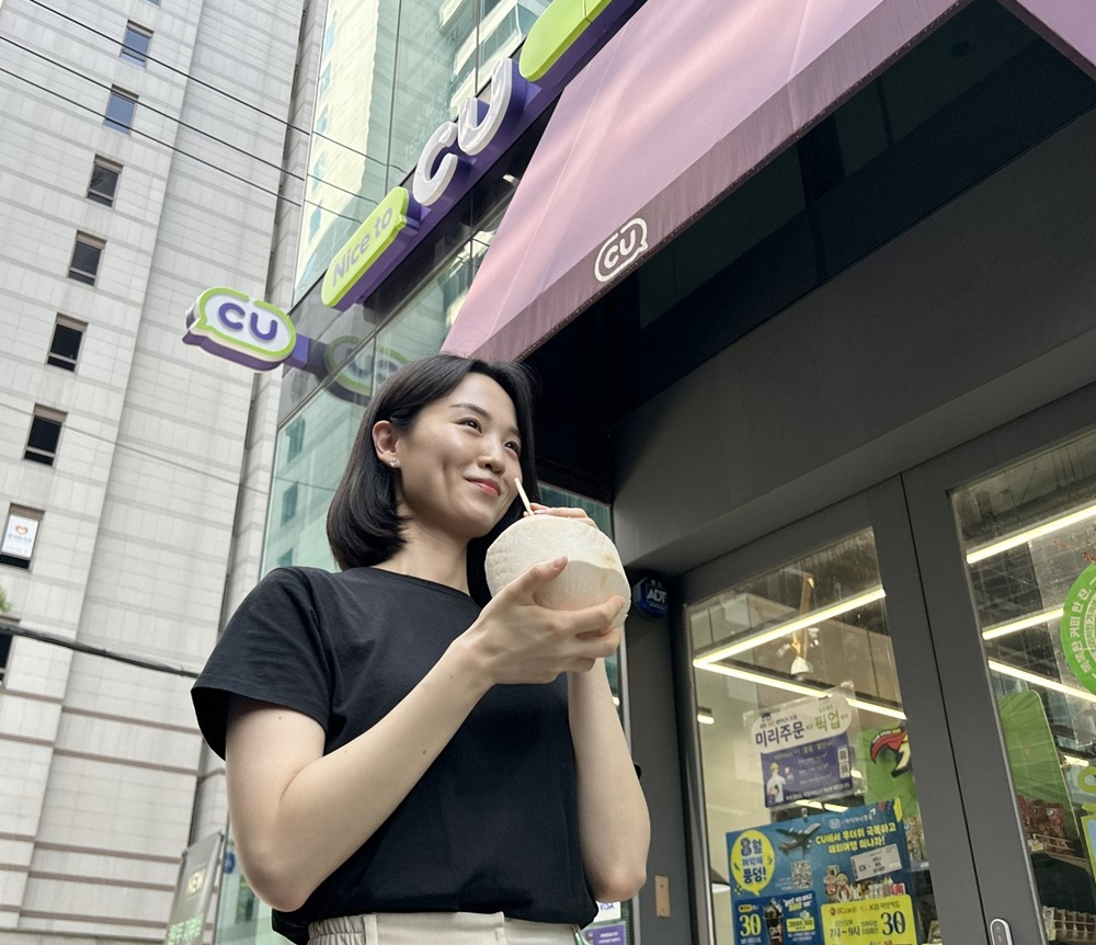 편의점 CU가 동남아시아 과일인 코코넛과 파인애플을 선보인다. 모델이 대나무 빨대를 꽂은 코코넛을 즐기고 있다. [CU 제공]