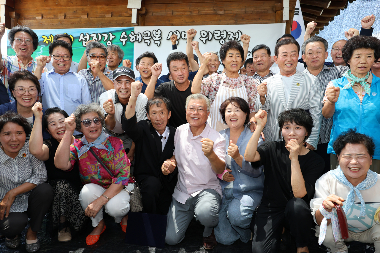 문재인 전 대통령과 부인 김정숙 여사가 8일 오전 전남 구례군 구례읍 양정마을에서 섬진강 수해 극복 3주년을 맞아 열린 구례양정마을과 경남 양산시 평산마을 간 자매결연 행사에 참석해 주민과 기념촬영하고 있다.[연합]