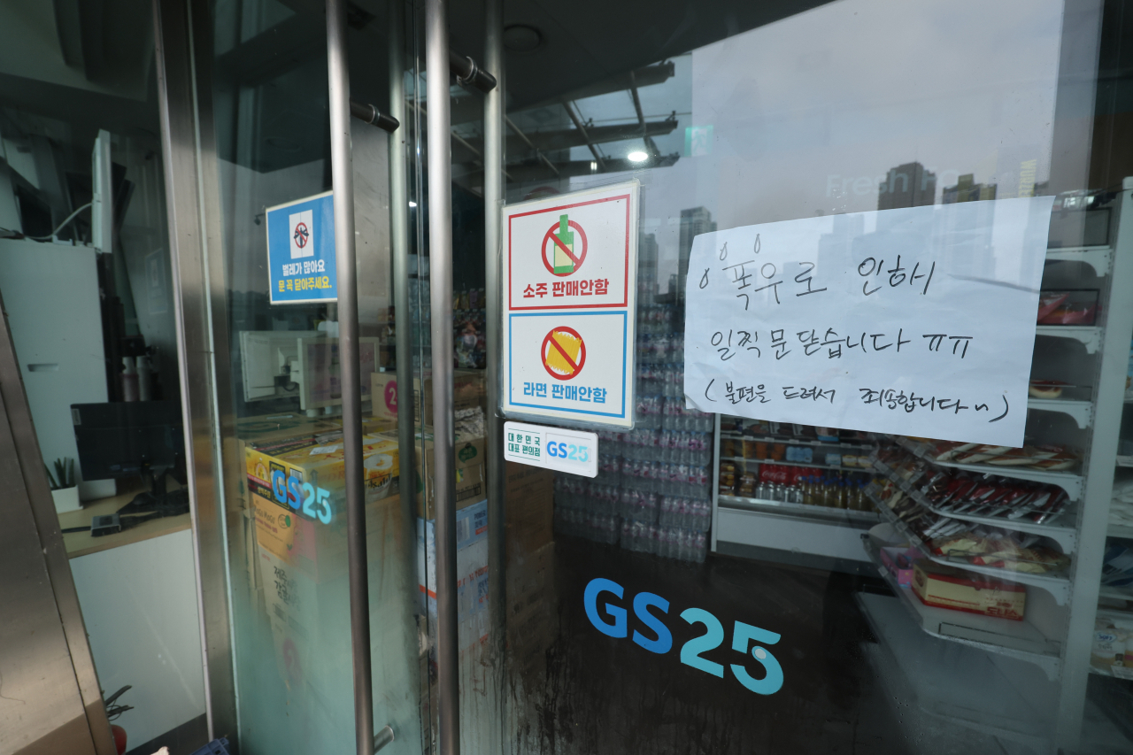 집중호우가 지나간 지난달 12일 오전 서울 서초구 반포 한강공원 내 위치한 편의점에 전날 폭우로 인해 영업을 조기 종료한다는 안내문이 붙어있다. [연합]