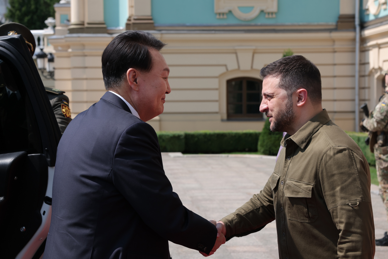 South Korean President Yoon Suk Yeol (Left) shakes hands with Ukrainian President Volodymyr Zelenskyy prior to their talks at the presidential palace in Kyiv on July 15. (South Korea's presidential office)