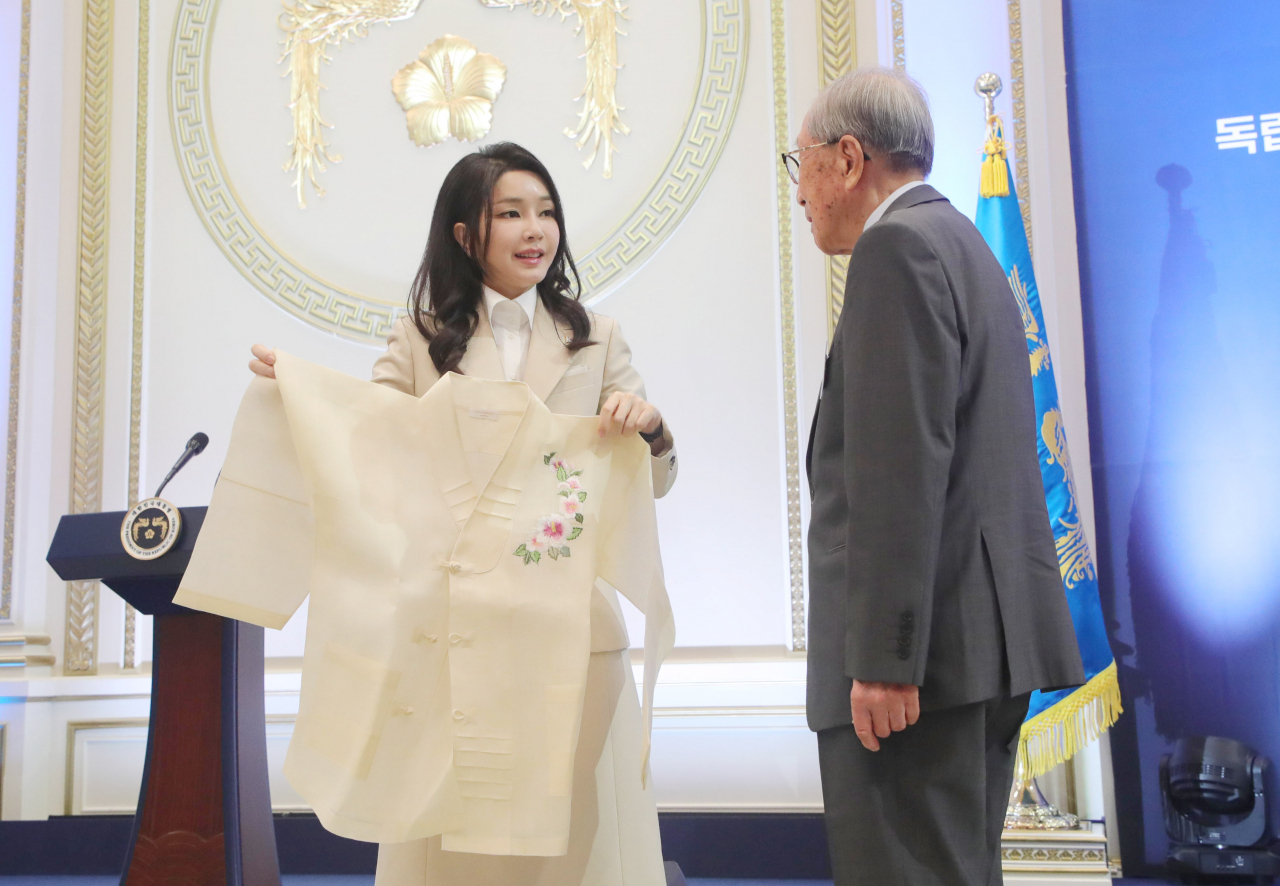 윤석열 대통령 부인 김건희 여사가 9일 청와대 영빈관에서 열린 독립유공자 및 유족 초청 오찬에서 김영관 애국지사에게 무궁화 자수 한산모시 적삼을 선물하고 있다. [연합]
