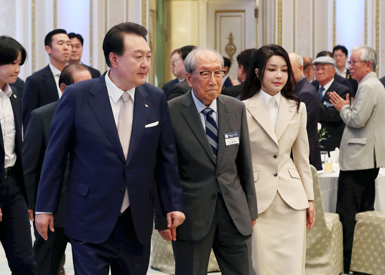 윤석열 대통령과 김건희 여사가 9일 청와대 영빈관에서 열린 독립유공자 및 유족 초청 오찬에 김영관 애국지사와 함께 입장하고 있다. [연합]