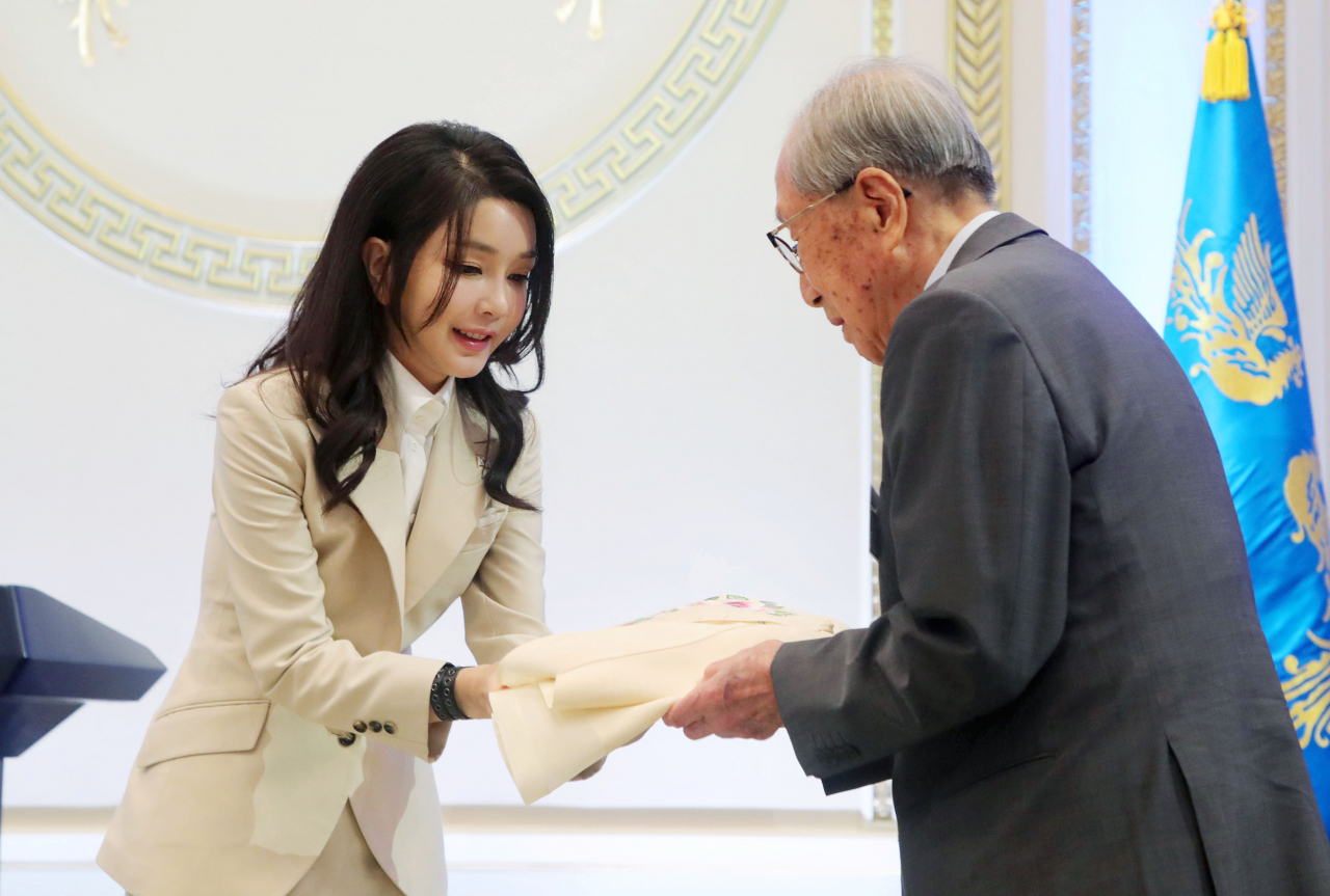 윤석열 대통령 부인 김건희 여사가 9일 청와대 영빈관에서 열린 독립유공자 및 유족 초청 오찬에서 김영관 애국지사에게 무궁화 자수 한산모시 적삼을 선물하고 있다. [연합]