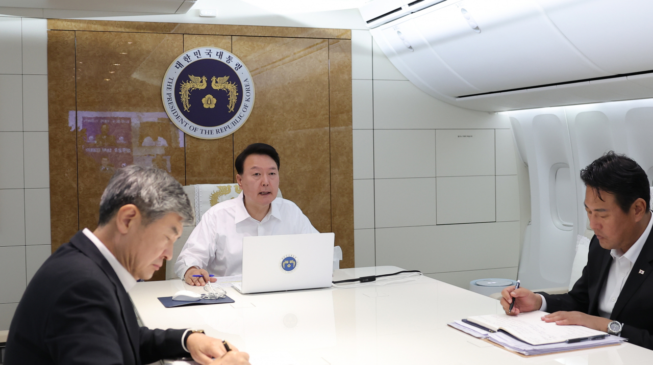 우크라이나를 전격 방문을 마친 윤석열 대통령이 지난 7월 16일(현지시간) 폴란드 한 지방공항에서 바르샤바 쇼팽국제공항으로 향하는 공군 1호기에서 조태용 국가안보실장 등과 호우 대책회의를 하고 있다. [연합]