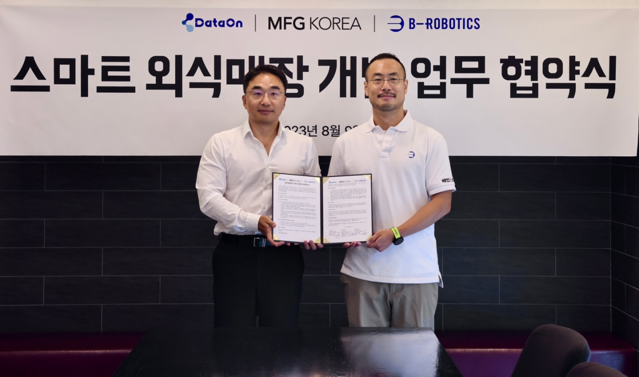 김민수(오른쪽) 비-로보틱스 대표와 윤나라 데이터온 대표가 10일 서울 중구 MFG코리아 본사에서 ‘스마트 외식매장 개발 업무 협약(MOU)’를 체결하고 기념 촬영을 하고 있다. [우아한형제들 제공]