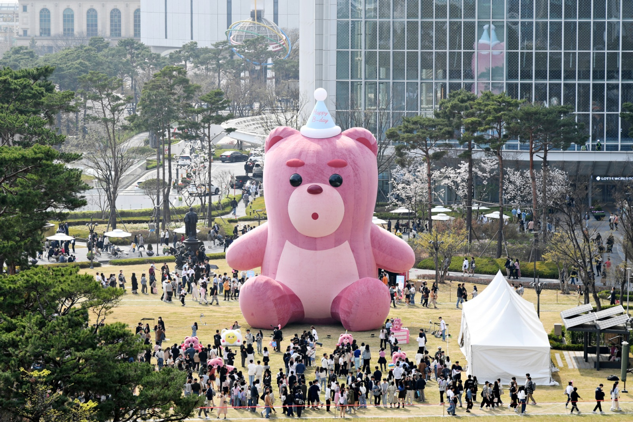 4월 서울 송파구 롯데월드타워 야외광장에서 열린 초대형 공공전시 ‘어메이징 벨리곰’에 방문한 관람객들이 2M 벨리곰 조형물과 함께 기념촬영을 하고 있다. [연합]