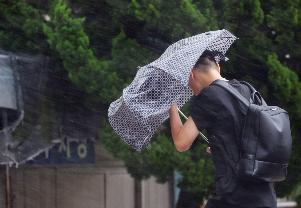 제6호 태풍 '카눈'이 남해안에 상륙을 앞두고 있는 10일 부산 해운대구에서 시민들이 강풍을 피해 힘겹게 출근길에 오르고 있다. 사진은 기사와 무관. [연합]