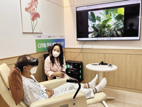 디지털 치유 정원 2호점이 설치된 서울재활병원에 입원 중인 환자가 국립세종수목원을 촬영한 가상현실(VR) 영상을 직접 체험하고 있다. [두나무 제공]