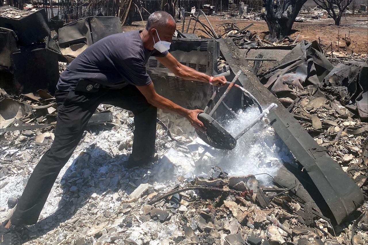 Anthony M. La Puente, 44, recovers items from his house in the aftermath of a wildfire in Lahaina, western Maui, Hawaii on Thursday. (AFP)