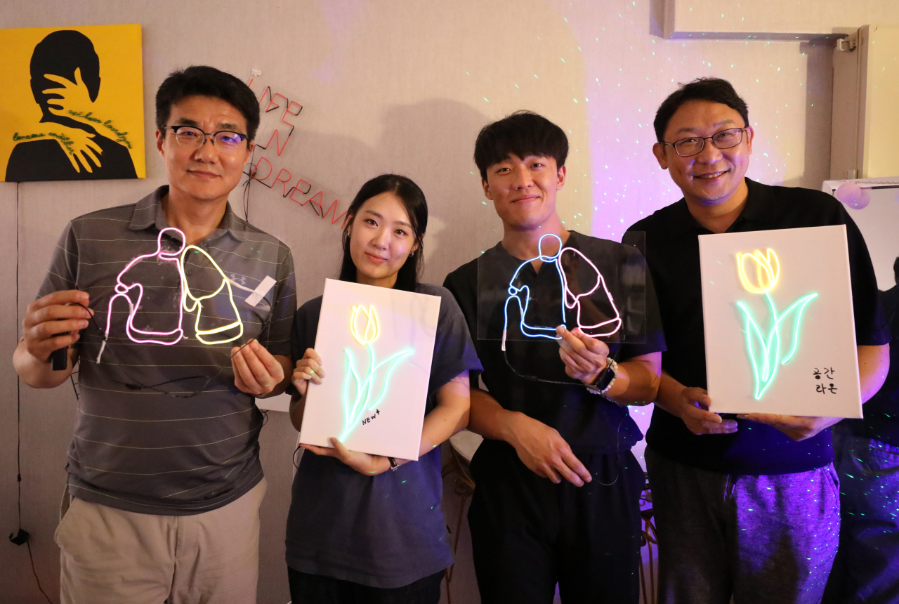김상수(왼쪽부터) LG유플러스 홍보·대외협력센터 상무, 박새린·조한희 학생, 권근섭 스마트팩토리사업담당이 10일 ‘리더 찐심데이(day)’ 프로그램인 네온사인 만들기 원데이 클래스 참여 후 기념촬영하고 있다. [LG유플러스 제공]