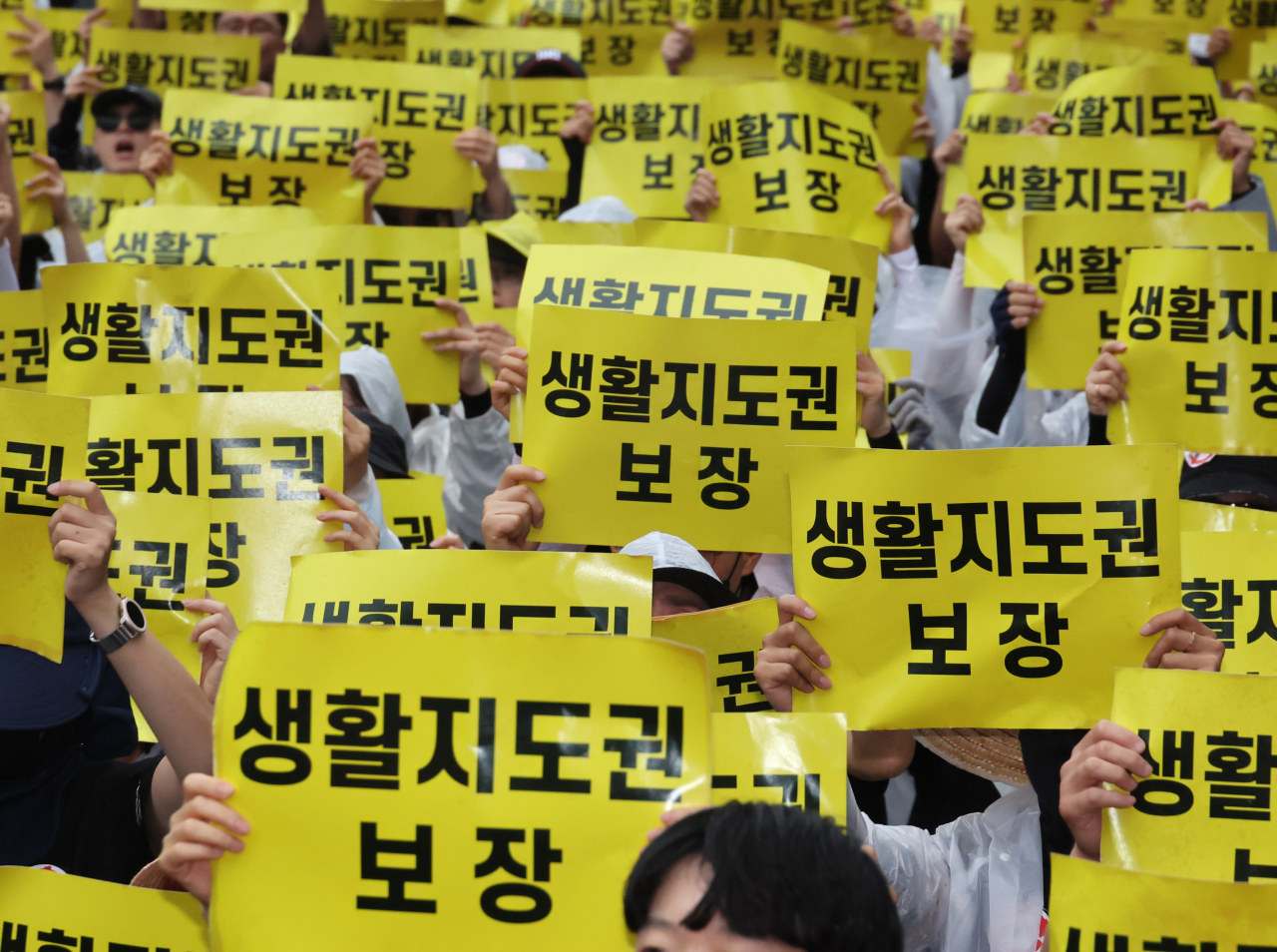 지난 12일 서울 종각역 인근 도로에서 열린 제4차 안전한 교육 환경을 위한 법 개정 촉구 집회에서 참여한 교사 등이 손팻말을 들고 구호를 외치고 있다. [연합]